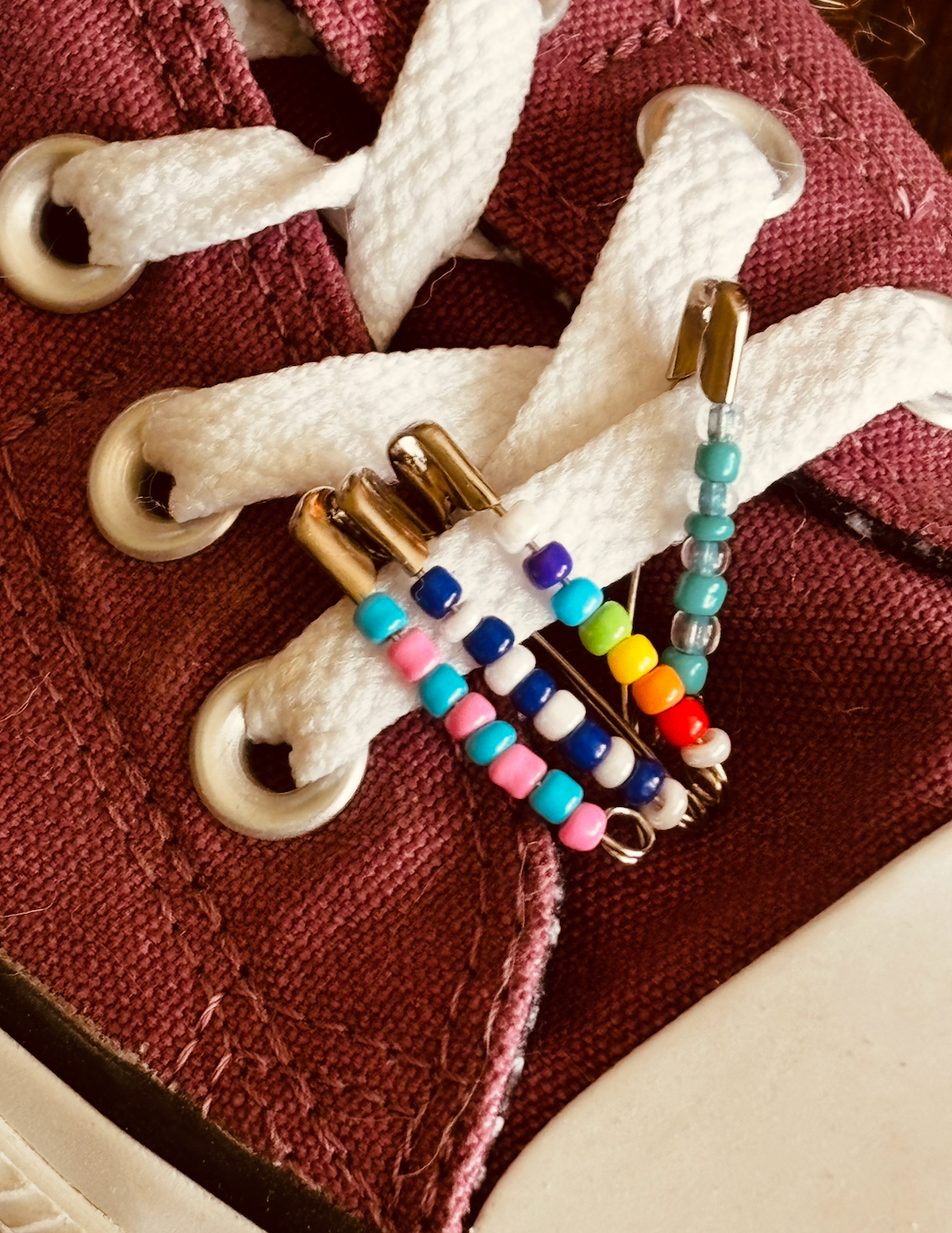 White sneaker decorated with a handmade friendship pin.