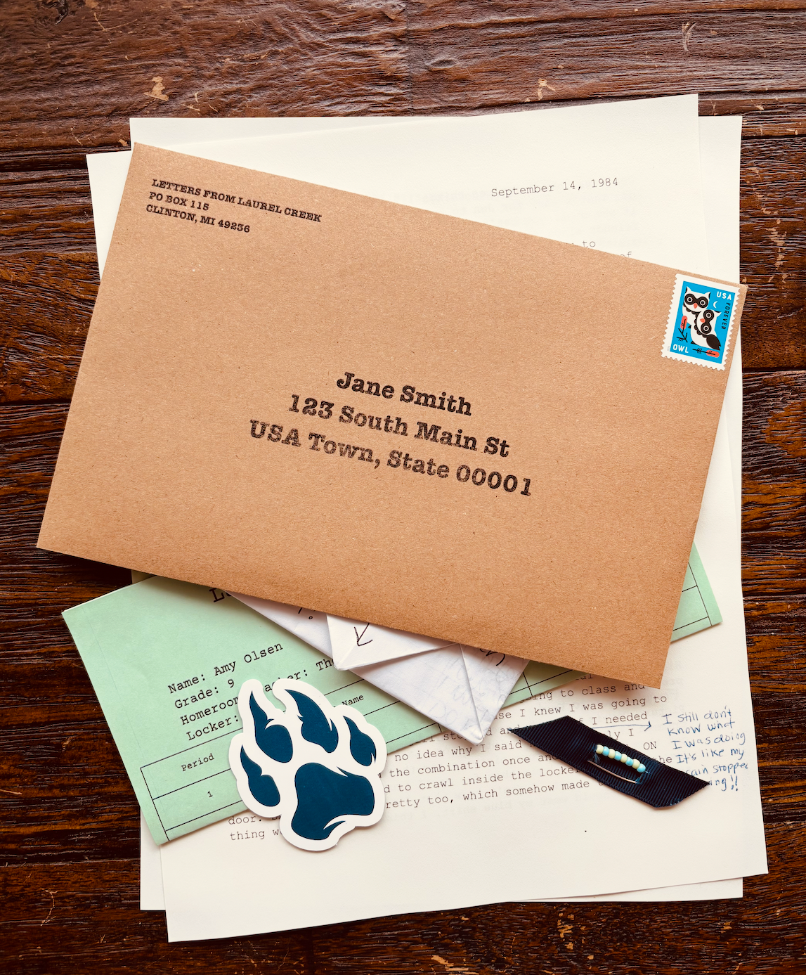 Letters from Laurel Creek mail package with envelope, typed letter, school schedule, folded note, friendship pin, and Wildcats sticker.